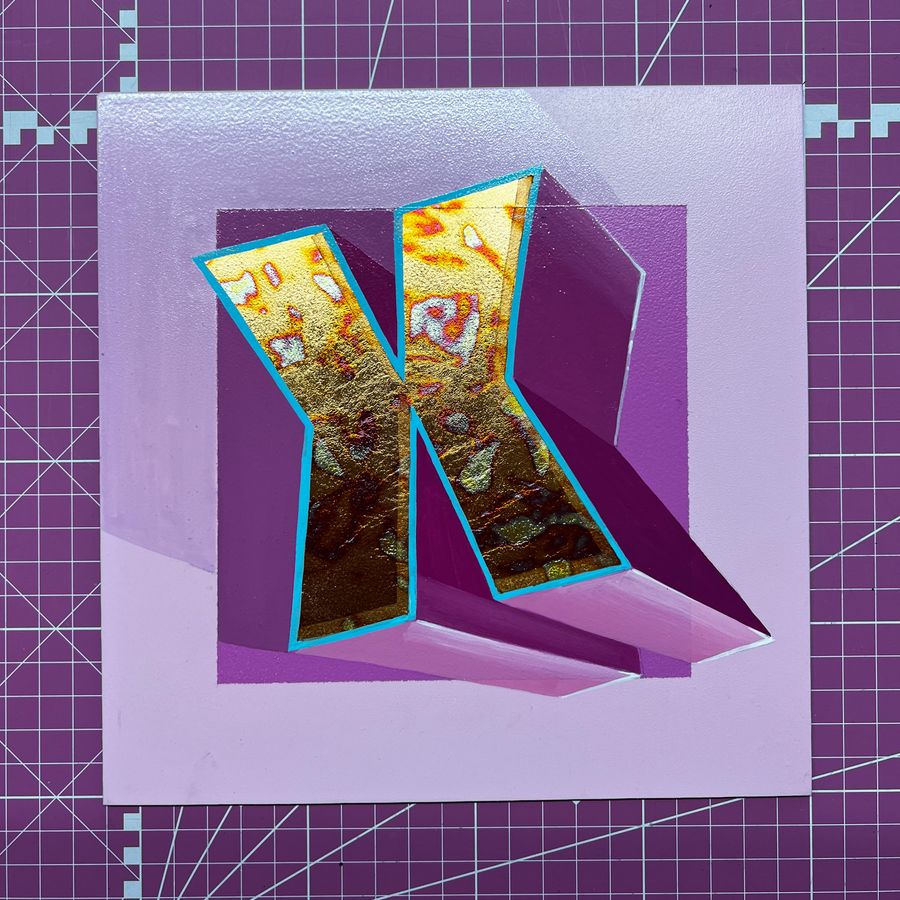 A gilded letter K with a blue outline and block shade on a purple panel