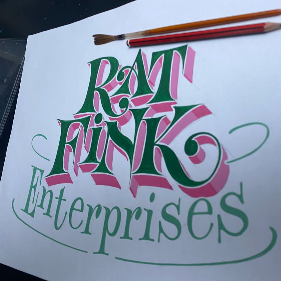 Rat Fink Enterprises lettered in green and pink script on paper, brushes alongside